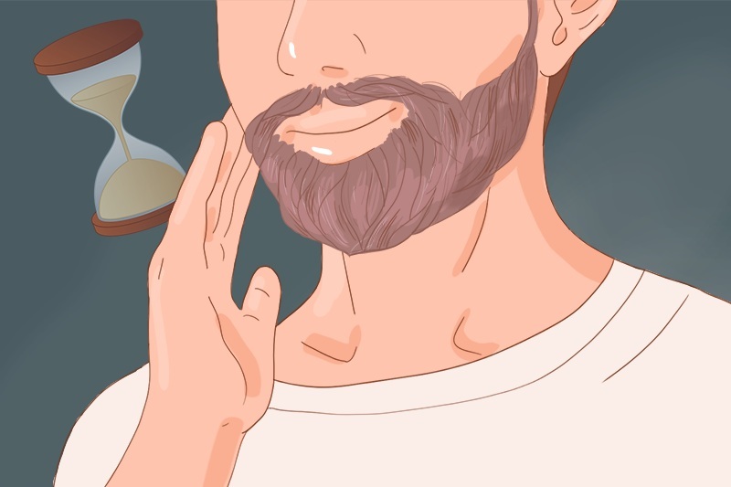 A man is touching his short brown beard
